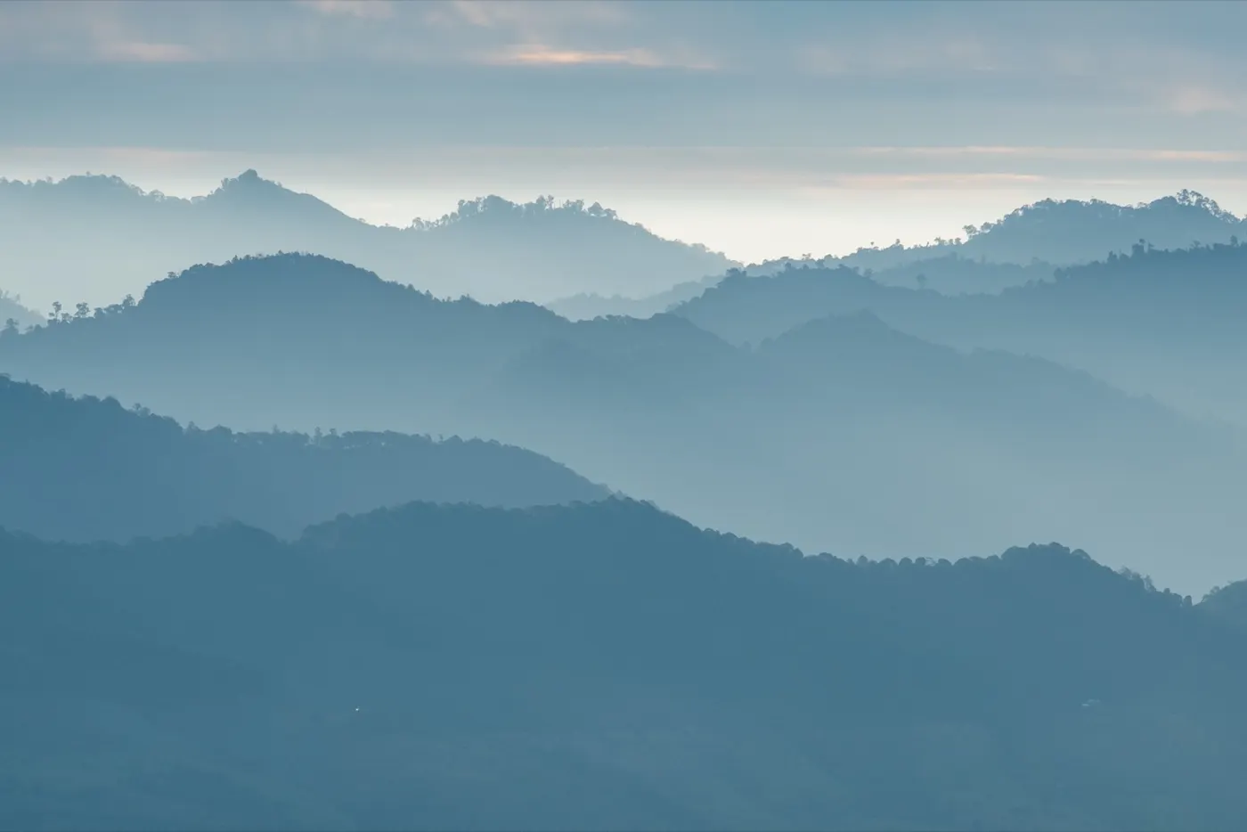 Layered mountain ridgelines fading into the hazy distance